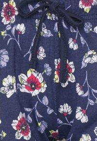 Blommönstrade shorts i marinblått bomull, med vita och röda blommor, dragsko i midjan och mjuk textur.