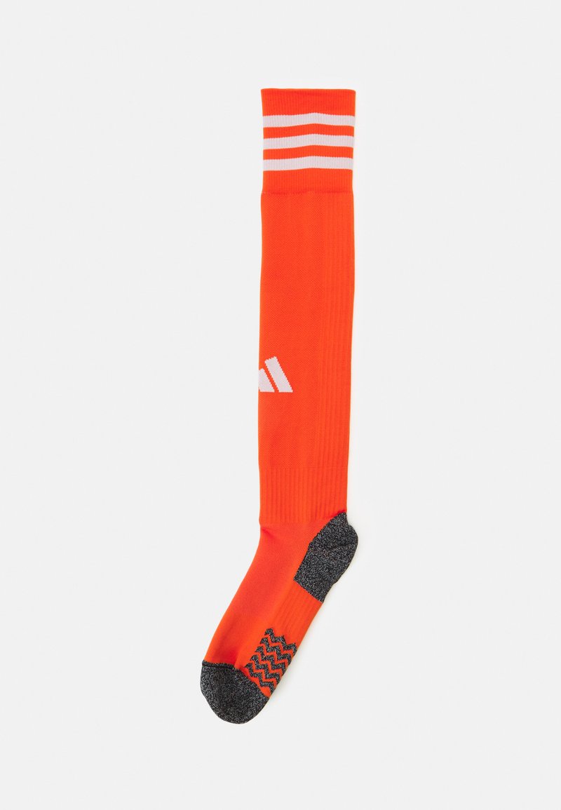 Knestrømpe i oransje med hvite striper og teksturert svart såle for bedre grep. Laget av elastisk, pustende materiale.