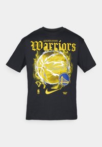 Sort T-shirt lavet af bomuld med gul "Warriors" tekst og en grafisk fremstilling af en basketball omgivet af gule og hvide lyn-effekter. Nike-logoet er til stede.