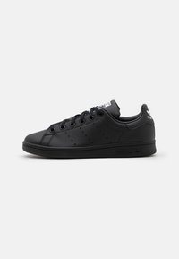 Sorte lædersneakers med runde snørebånd, perforerede detaljer på siderne, en polstret krave og en gummisål.