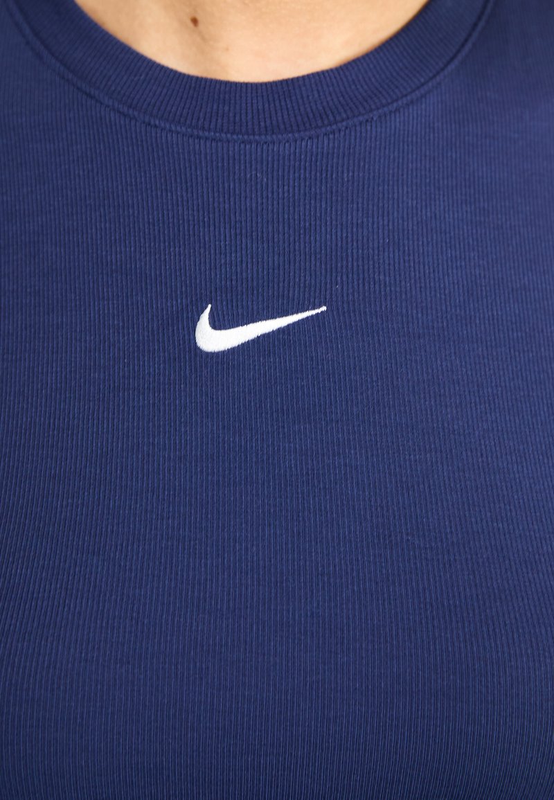 Camiseta sin mangas de canalé en color navy con un pequeño logo blanco de Nike en el pecho, hecha de un material elástico y con un cuello redondo.