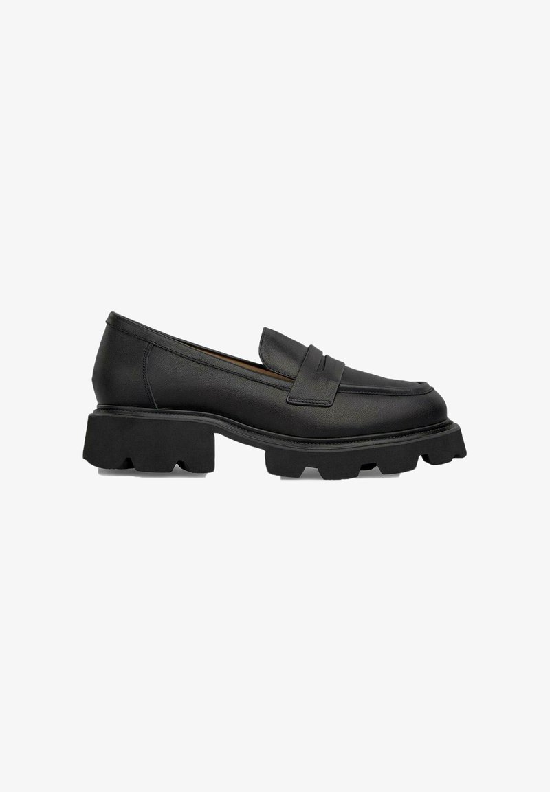 Zwarte leren instappers met een dikke rubberen zool, voorzien van een voorkeursbanddetail en een gladde afwerking. Ideaal voor veelzijdige, casual outfits.