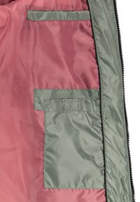 Windbreaker interior featuring a smooth pink lining with two green, patch pocket details on the left side. Zippered closure along the edge.