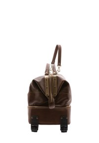 Borsa da viaggio in pelle marrone con due chiusure a zip, accessori in ottone e base con ruote. Presenta una maniglia corta e un design slanciato.