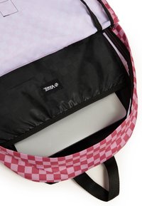 Interior de mochila con diseño de tablero de ajedrez rosa y forro negro, con compartimento para portátil y etiqueta de marca. Diseño estructurado y forrado.