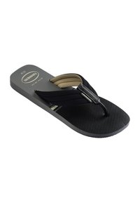 Zwarte Havaianas teenslipper met een gestructureerde zool en stoffen bandjes, voorzien van een beige gevoerde voering en branding op de band en het voetbed.