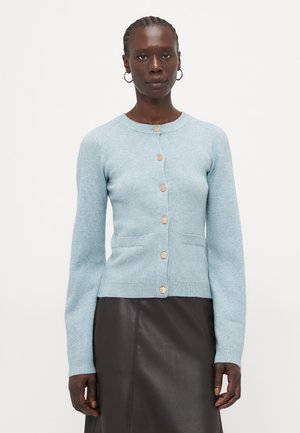 Cardigan bleu clair en tissu doux, avec un col rond, une fermeture à boutons sur le devant, deux poches avant et des poignets et un ourlet côtelés.