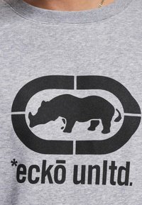 Gray sweatshirt featuring a large black graphic of a rhino and an enclosed logo with the text "*eckō unltd." at the bottom.