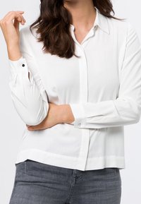 Witte, langmouwige, knoopsluiting blouse met een kraag en manchet mouwen. Heeft een gladde textuur en een rechte zoom. Casual pasvorm.