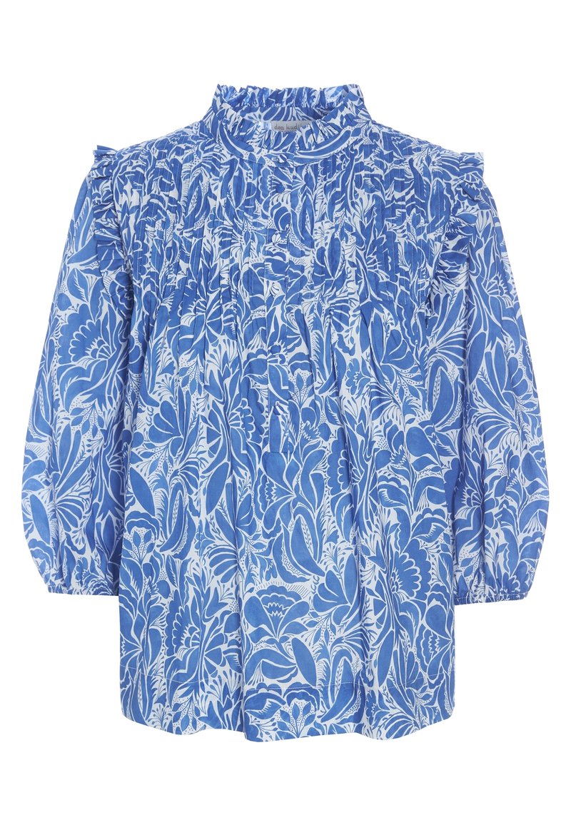 Blusa floreale blu con collo a ruffles plissettato, maniche lunghe a sbuffo e intricati motivi di fiori bianchi su uno sfondo azzurro chiaro.