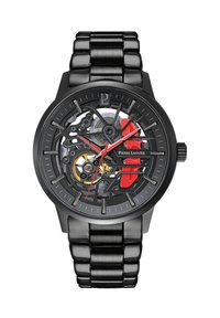 Skeleton watch with a black stainless steel strap, black dial, red accents, and visible gears. Features minimalist hour markers and hands.
