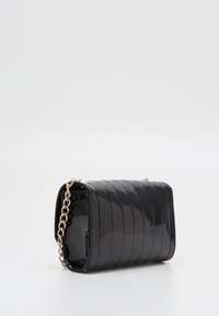 Borsa a tracolla in pelle sintetica nera con design a righe, forma rettangolare e tracolla in catena dorata. Texture liscia con finitura lucida.