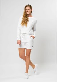 Witte katoenen sweatshirt- en shortset met geribbelde textuur, voorzien van een klein logo op de borst en zakken in de shorts.
