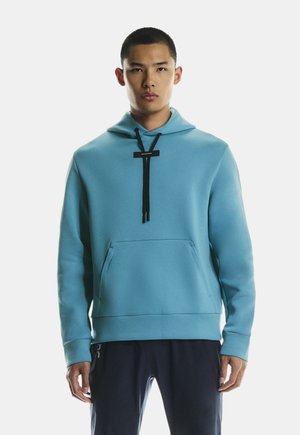 Light blue hoodie with a kangaroo pocket, black drawstrings, and a relaxed fit. Soft texture and ribbed hem.