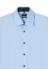 Hellblaues, super schlank geschnittenes Hemd mit strukturiertem Stoff, spitzem Kragen und schwarzen Knöpfen entlang der Vorderseite. Der innere Kragen hat ein Muster.