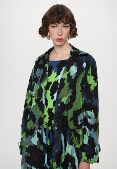Long, multicolored trench coat featuring a camouflage pattern in shades of green, blue, and black with a button front and collar.