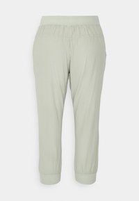 Pantalon court vert clair avec taille élastique et ourlets retroussés ; tissu léger et lisse avec une coupe décontractée.