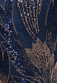 Blauer Stoff mit filigranen goldenen und marineblauen Pailletten in Blumen- und Blattmustern, die ein schimmerndes dekoratives Design erzeugen.