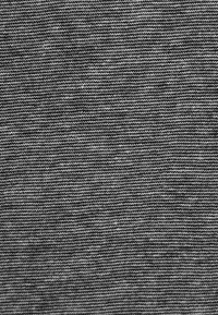 Šedá pletenina s jemnou ribovanou strukturou, s pravidelně se střídajícími tmavě šedými a světle šedými pruhy. Měkký, hladký povrch.