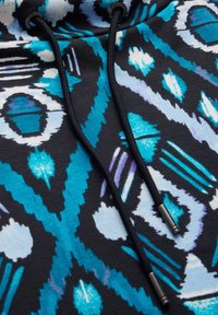 Hoodie met een zwarte basis en een blauw-wit abstract patroon. Inclusief zwarte trekkoorden met metalen aglets.