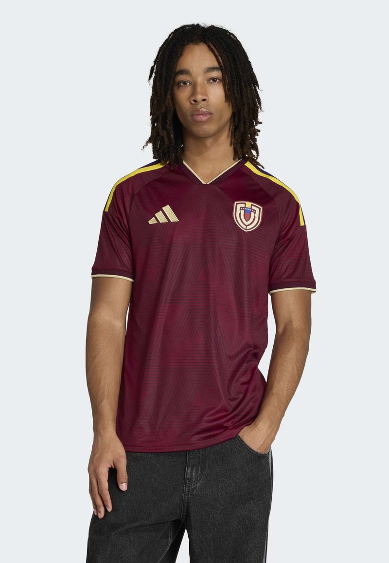Burgundy soccer jersey with a V-neck, gold accents, and subtle geometric pattern. Features Adidas logo and team emblem on the chest.
