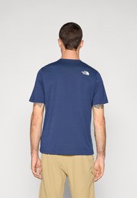 Navyblauwe t-shirt met korte mouwen, gemaakt van zachte stof, met een klein wit logo op de bovenrug. Eenvoudig ontwerp met ronde hals.