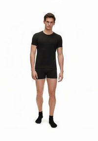 T-shirt aderente nera a maniche corte e boxer abbinati con una texture liscia, indossati con calzini neri. Design semplice e elegante.