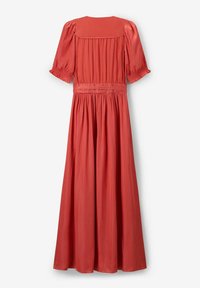 Robe maxi en corail uni avec des manches courtes bouffantes, un corsage froncé et une jupe fluide. Fabriquée en tissu léger au toucher doux.