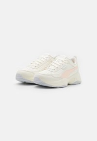 Sport shoes featuring a cream synthetic upper with a peach accent, textured overlays, and a cushioned rubber sole in grey.