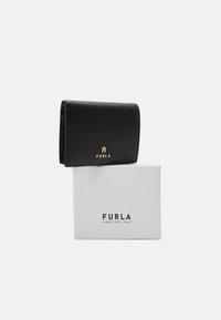 Portefeuille en cuir noir avec une finition texturée et un logo doré, exposé sur une boîte blanche avec des lettres noires.