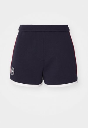 Pantalones cortos deportivos de color azul marino con una franja lateral blanca y roja, un dobladillo blanco y un logotipo circular en la pierna izquierda. Textura de tela suave.