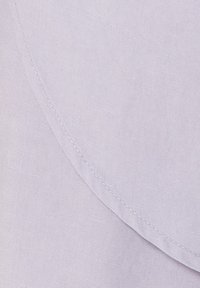 Helle lila Stoff mit einer glatten Textur und subtiler Glanz, mit einer gebogenen Naht und ordentlichem Nähdetail.