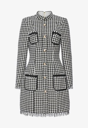 Sukienka w czarno-białą kratkę z wysokim kołnierzem, złotymi guzikami, dwoma przednimi kieszeniami z kontrastowym wykończeniem oraz wykończeniem z frędzlami.