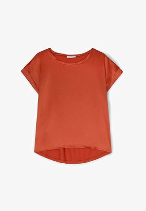 Short-sleeve top in rust orange, featuring a round neckline, soft fabric, and slightly curved hem. Simple design with no patterns.