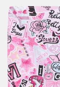 Roze stof met patronen van sterren, rozen, harten, vlinders, nagellak, rolschaatsen en het woord "Guess" in verschillende stijlen.