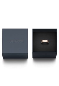 Hopeinen sormus kiillotetulla pinnalla, jossa on ruusukultainen aksenttirengas, esillä tummansinisessä laatikossa, jossa on musta vuori.