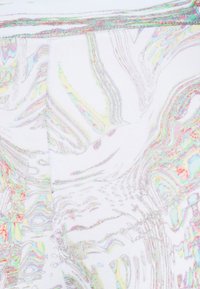 Legíny s vysokým pasem z bílé látky s iridescentními, vlnitými vzory a kontrastními švy. Měkká textura s hladkým povrchem.