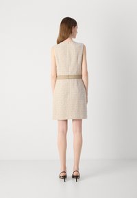 Beige tweedmekko vyöllä, hihaton muotoilu, teksturoitu kangas, polvenpituinen, jossa on sileä vyötäröosa ja piilotettu vetoketju takana.