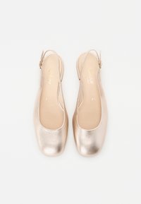 Metalliska guld ballerina skor med rund tå och slingbacksdesign. Slät lädertextur och diskret branding på innersulan.