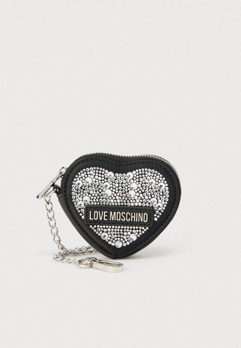 Μικρό πορτοφόλι σε σχήμα καρδιάς, κατασκευασμένο από συνθετικό υλικό, διακοσμημένο με ασημένιες τρουκς και πλακέτα με λογότυπο, με αλυσίδα για προσάρτηση.
