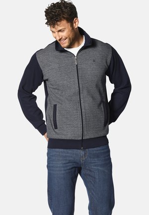 Herren Jacke mit Reißverschluss, grauem strukturiertem Körper, navyfarbenen Ärmeln und Kragen. Verfügt über Vordertaschen und ein geripptes Bündchen für einen guten Sitz.