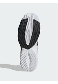Podeszwa czarno-białego obuwia sportowego z teksturowanym, żłobkowanym wzorem bieżnika zapewniającym przyczepność na jasnym, jednolitym tle.