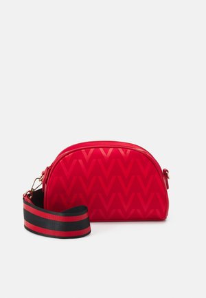 Petit sac bandoulière rouge avec motif V embossé et large bandoulière réglable rayée noire et rouge, fermeture éclair avec quincaillerie dorée.