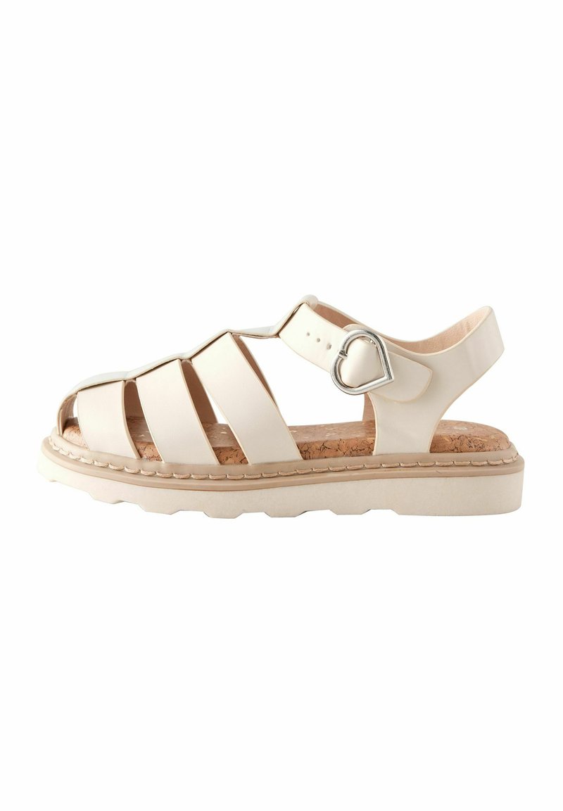 Ljusbeige sandal med flera öppna remmar, korkinsats, gummisula och en hjärtformad metallaccent på den justerbara vristremmen.