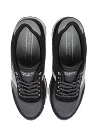 Svart och grå atletiska skor med mesh och syntetiska material, som har en vadderad krage, snörningsdesign och små accentlinjer.