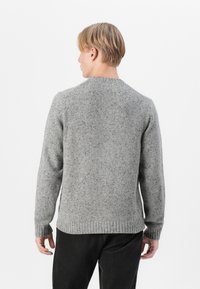 Gray knit sweater with a crew neck, featuring ribbed cuffs and hem. Multi-toned texture adds depth to the fabric. Simple, clean design.