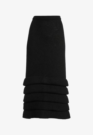 Jupe midi noire en tricot avec taille haute et volants horizontaux superposés près de l'ourlet.