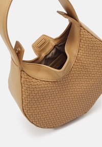 Sac à main en cuir tressé tan, de forme arrondie, avec double poignées et une petite ouverture. L'intérieur présente un doublure en tissu contrasté.