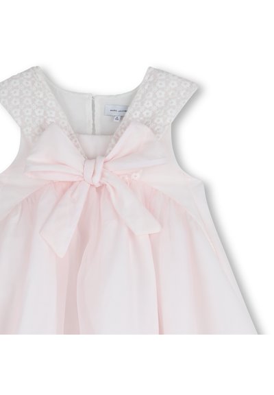 Φόρεμα απαλό ροζ με δαντελένιες ανθικές λεπτομέρειες στους ιμάντες των ώμων, φιόγκο στη μέση και φουσκωτή φούστα με απαλή υφή.