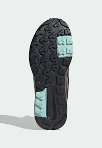 Black rubber shoe sole with textured tread for grip. Features mint green accents and a central black section with the brand name.
